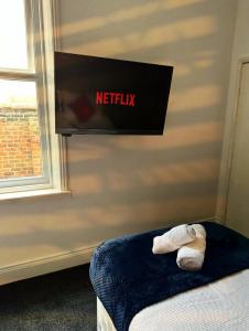 a bedroom with a netflix sign on the wall at A&A Luxury Stay Bettys in Pallion