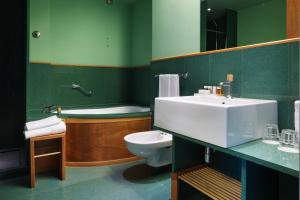 a green bathroom with a sink and a toilet at Towers Hotel Stabiae Sorrento Coast in Castellammare di Stabia