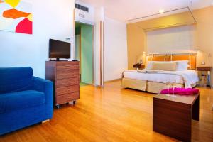 - une chambre avec un lit et un canapé bleu dans l'établissement Towers Hotel Stabiae Sorrento Coast, à Castellammare di Stabia