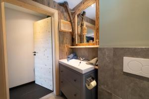 a bathroom with a sink and a mirror at klein und fein wohnen UNT in Mittersill