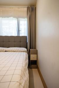 een kleine slaapkamer met een bed en een raam bij Shore 3 Residences, Mall of Asia Complex in Manilla