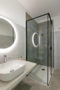 bagno con lavandino e doccia in vetro di Sa Pasadina a Àrbatax