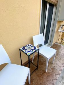 two white chairs and a table on a patio at Albergo Mendolia in Milazzo