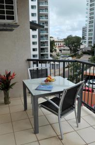 una mesa y sillas en un balcón con vistas en Inner city Cardona Court apartment, en Darwin