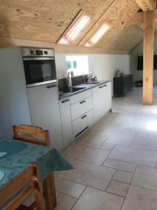 een keuken met witte kasten en een fornuis met oven bij De Dagloner in Nieuwlande