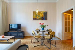 a living room with a table and chairs and a tv at Beautiful fully equipped by the Main Square in Krakow