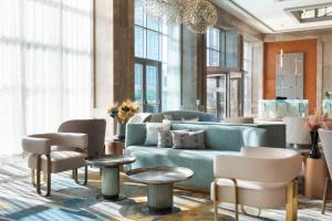 a lobby with a blue couch and chairs and a chandelier at Sheraton Bursa Hotel in Bursa