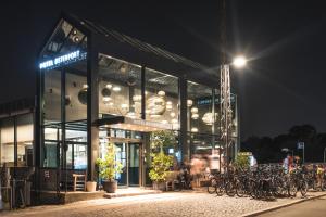 un bâtiment avec des vélos garés à l'extérieur la nuit dans l'établissement Hotel Østerport, à Copenhague