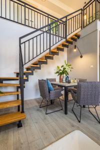 a dining room with a table and a staircase at Apartament24 Stare Miasto Wrocław in Wrocław