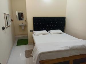 a bedroom with a large bed with a black headboard at Anand Vihar in Jamshedpur