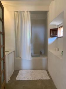 a bathroom with a white shower curtain and a bath tub at Son Rullan in Deia