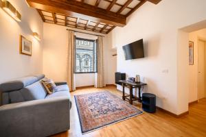 a living room with a couch and a television at B&B Soggiorno Battistero in Florence