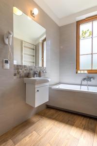 a bathroom with a tub and a sink and a mirror at Apartament24 Stare Miasto Wrocław in Wrocław