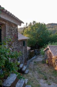 een stenen huis met een pad naar een tuin bij Horizontes Serranos in Tondela