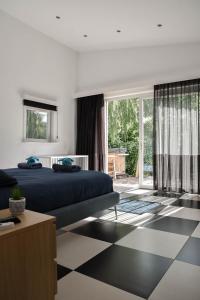 a bedroom with a bed and a black and white checkered floor at Spacious Comfort Villa Vera with hottub in Zeewolde