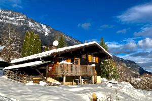 a log cabin in the snow in front of a mountain at Chalet Flobelle in Entremont