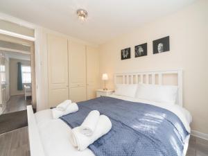 una camera da letto con un grande letto con asciugamani di Pass the Keys Spacious 4 Bed House Free Parking Near Station a Bexleyheath