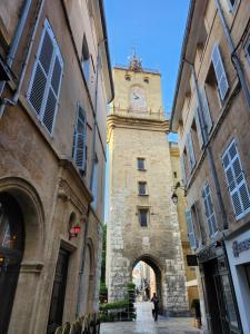 un bâtiment avec une tour d'horloge dans une rue dans l'établissement Le Beffroi de Gaston, à Aix-en-Provence