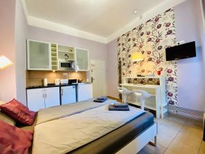 Habitación pequeña con cama y cocina en Purple Room - Stylish and lively central studio en Budapest