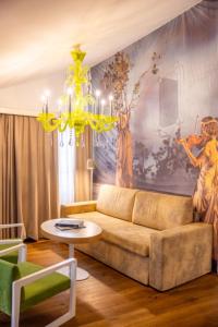 ein Wohnzimmer mit einem Sofa und einem Kronleuchter in der Unterkunft Small Luxury Hotel Goldgasse in Salzburg