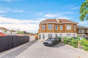 uma casa com um carro estacionado na entrada em Modern 3 bed Entire House, Gym & Underfloor Heating em Hersham