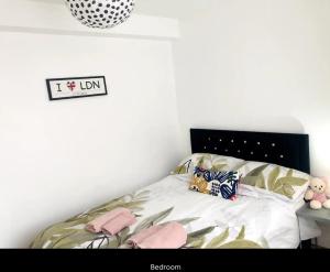 a bedroom with a bed with pink pillows on it at Peaceful flat in Central London in London