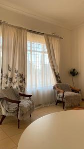 Plateau Home في كاسان: غرفة معيشة مع كرسيين ونافذة