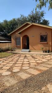 una casa con una entrada de piedra delante de ella en Plateau Home, en Kasane