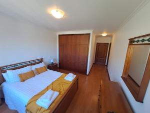 Un dormitorio con una cama grande con dos toallas encima. en Ocean Gardens, en Caniço