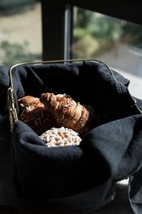 a basket of bread and pastries next to a window at Bucolico Monza in Monza