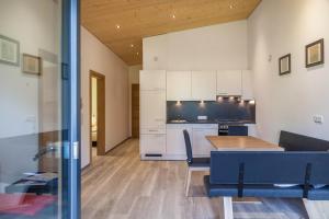 a kitchen and living room with a wooden table and a dining room at Kwelle zur Natur Rehwiese in Obernberg am Brenner