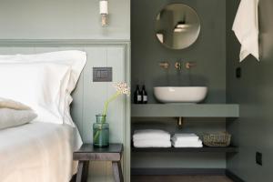 a bedroom with a bed and a bathroom with a sink at Bucolico Monza in Monza