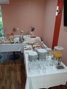 een tafel met twee tafels met borden eten en drinken bij Pensiune Safrane in Băile Herculane