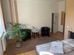 1 dormitorio con cama, mesa y planta en Loensches Gut, en Görlitz