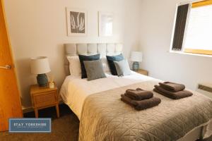 a bedroom with a bed with two towels on it at Stay Yorkshire City Centre Apartments in Sheffield