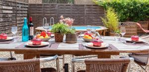 uma mesa de madeira com frutas e copos de vinho em Au Paradis des 2 Petites Abeilles em Félines-Minervois