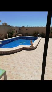 a swimming pool with a statue in front of a building at Spanish Villa in Torre del Rame