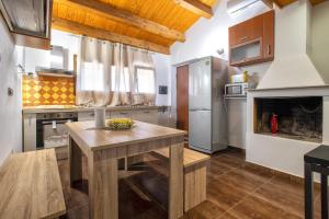 eine Küche mit einem Holztisch und einem Kühlschrank in der Unterkunft Beb Mediterraneo Guest House in Porto Torres