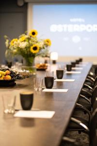 une grande table avec des tasses, des assiettes de nourriture et des fleurs dans l'établissement Hotel Østerport, à Copenhague