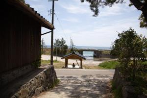 Kawajiriにある海辺の古民家ホテル　奥能登じろんどん（一棟貸宿）の水辺の展望台に座る者