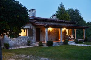 a stone house with lights on the front of it at CASA DO COMBRO in Ponteareas