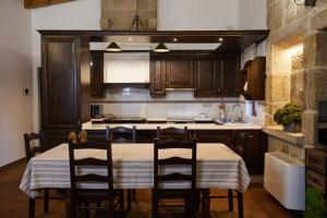 a kitchen with a table with chairs and a sink at CASA DO COMBRO in Ponteareas