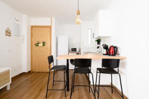 a kitchen with a wooden table and black chairs at Rosales Canteras in Las Palmas de Gran Canaria