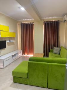 sala de estar con sofá verde y TV en Hotel Adria, en Shëngjin