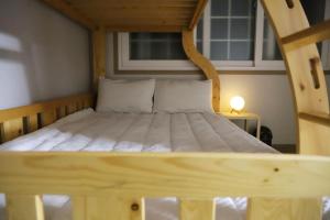 Bett in einem Zimmer mit einem Bettrahmen aus Holz in der Unterkunft Tongyeong Hue Stay in Tongyeong
