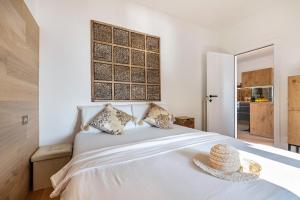 um quarto com uma cama branca e um chapéu de palha em Wohnung Assenza em Brenzone sul Garda
