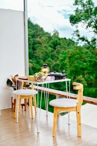 einen Tisch und Stühle vor einem Fenster in der Unterkunft ภูสกาย โฮมสเตย์ in Mon Jam