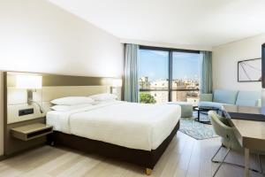 a hotel room with a large bed and a desk and a desk at AC Hotel by Marriott Nice in Nice