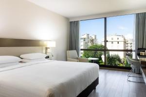 ニースにあるAC Hotel by Marriott Niceのベッドと大きな窓が備わるホテルルームです。
