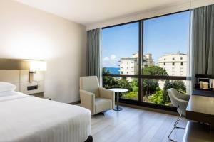 Cette chambre comprend un lit et une grande fenêtre. dans l'établissement AC Hotel by Marriott Nice, à Nice